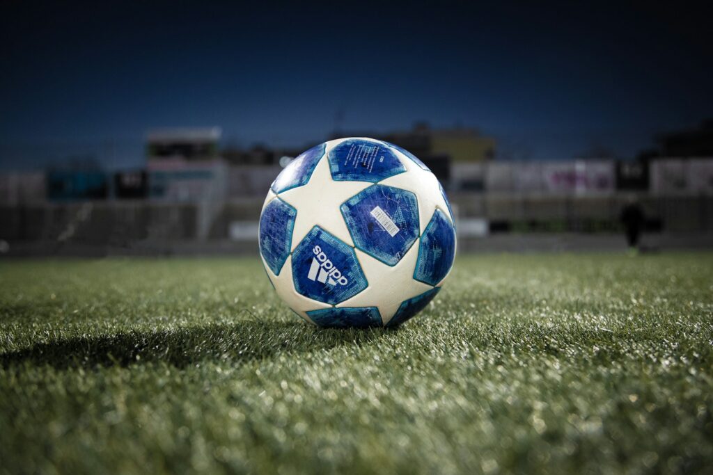 Photo by Janosch Diggelmann white blue soccer ball on green grass field during daytime